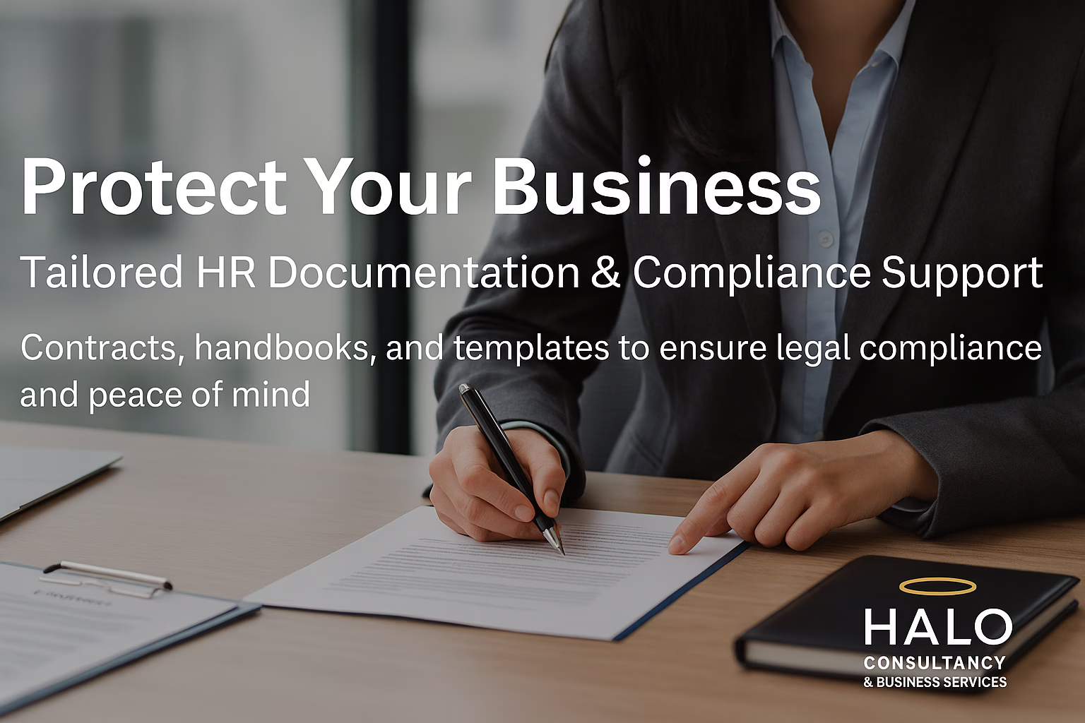 A professional woman in a business suit reviews HR documents at a desk, representing tailored HR documentation and compliance support from Halo Consultancy & Business Services.